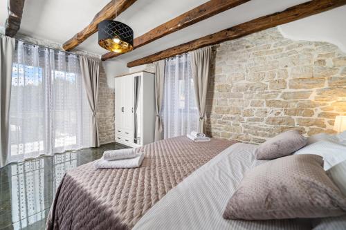 a bedroom with a large bed with a stone wall at Villa Istria Mar in Pazin