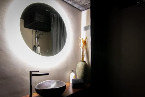 a bathroom with a round mirror and a sink at Stylish City Suite in the Heart of Jyväskylä in Jyväskylä