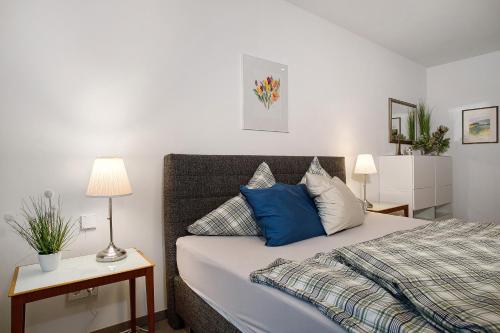 a bedroom with a bed with blue and white pillows at Kapps Haus in Langenargen