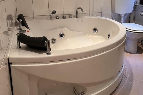 a white bath tub with a black high heel shoe sitting on a toilet at Beautiful 8 Bed Apartment in Hallenberg in Hallenberg