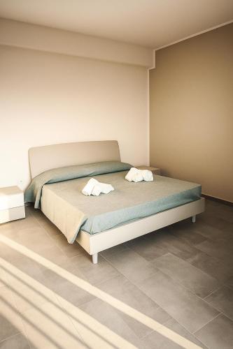 a bedroom with a bed with two towels on it at Acquaria Case Vacanze in Marsala