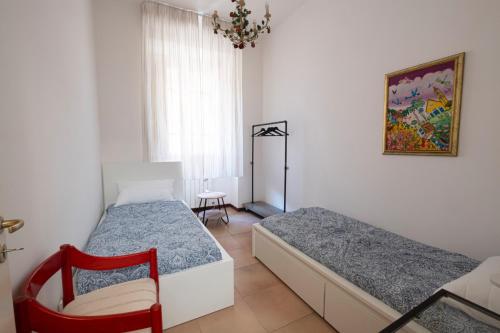 una camera da letto con due letti e una sedia di San Lorenzo by the sea ad Augusta