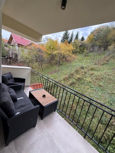 ein Wohnzimmer mit einem Sofa und einem Tisch auf dem Balkon in der Unterkunft Alpine Eden Hideaway in Râșnov