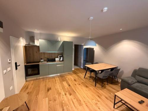 ein Wohnzimmer und eine Küche mit einem Tisch und einer Couch in der Unterkunft Alpine Eden Hideaway in Râșnov