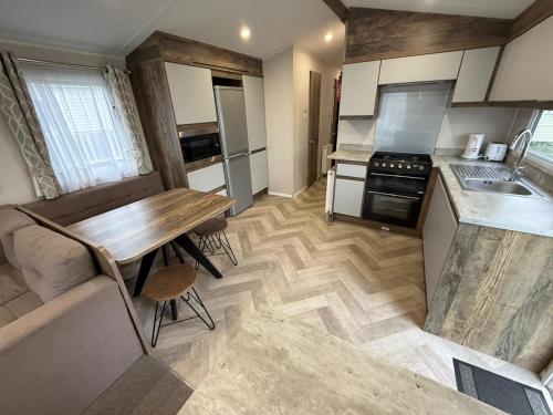 eine Küche mit Holztisch und Holzboden in der Unterkunft Oscars Inn, West Sands, Seal Bay Resort in Selsey