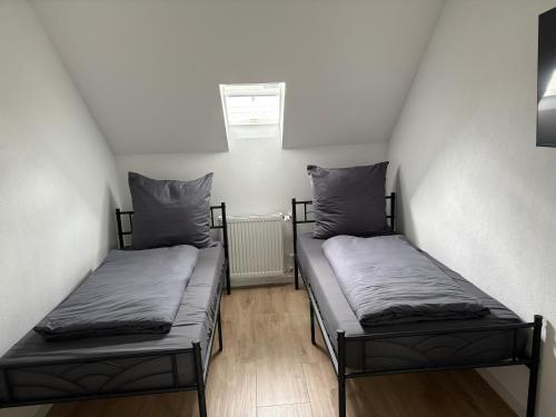 two beds in a small room with a window at RheinSchatz Apartments 3 in Oberwesel