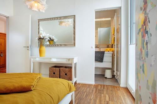 a bedroom with a yellow bed and a bathroom at Kapps Haus in Langenargen