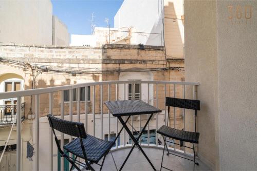 two chairs and a table on a balcony at Seaside Comfort in St'Pauls Bay steps from the Sea by 360 Estates in St Paul's Bay
