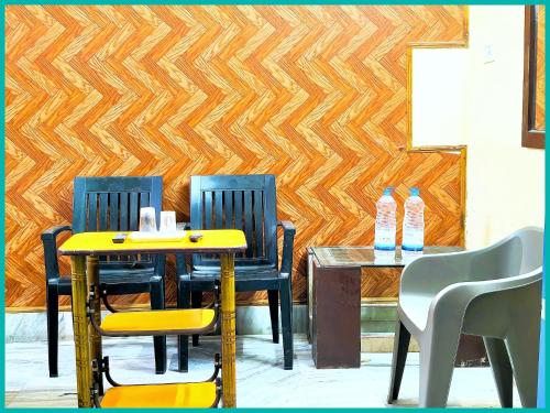 two chairs and a table in a room with a wooden wall at Hotel Shilpa Teerth Palace Guest House Near Vishwanath Temple - #Fully Air Conditioned Rooms #Restaurant And Wi-fi Facility - Best Prmium Hotel In Varanasi in Kashi