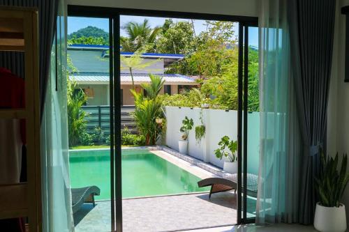 a view of a swimming pool from a room with sliding glass doors at Modern 2BR Pool Villa - Near Ao Nang Beach in Ao Nang 