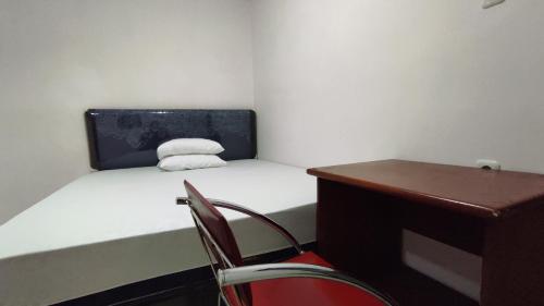 BarruにあるHotel O Wisma Syariah Dian Near Pare-pareのベッド、椅子、机のある小さな部屋