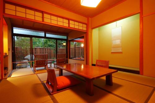 a dining room with a wooden table and chairs at Ginka in Toyooka