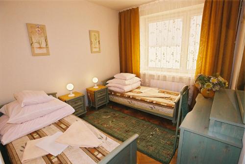 two twin beds in a room with a window at Jawor in Polańczyk