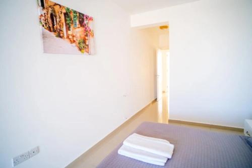 ein Zimmer mit einem Bett und einem Gemälde an der Wand in der Unterkunft Spacious Three-Bedroom Apartment A3 in Sanctuary Cove site in Kyrenia