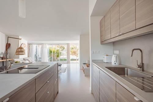 a white kitchen with a sink and a counter at Villa L’hirondelle in La Michelière