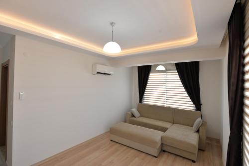 a living room with a couch and a window at Arti̇m Apart Hotel in Fethiye