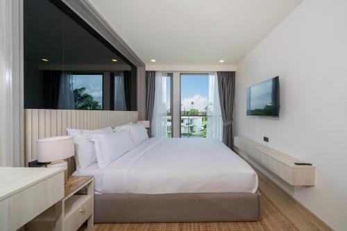 a bedroom with a large white bed and a window at Ozone Condominium BangTao Laguna Area in Phuket