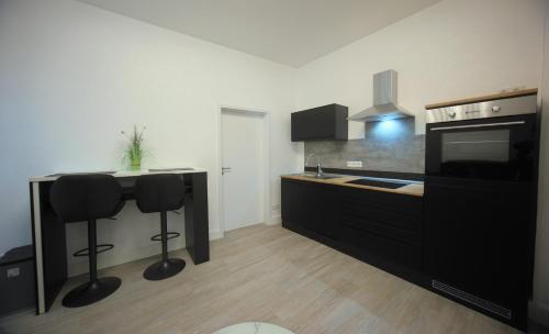 a kitchen with a counter and two bar stools at Appartment Junior Suite in Springe