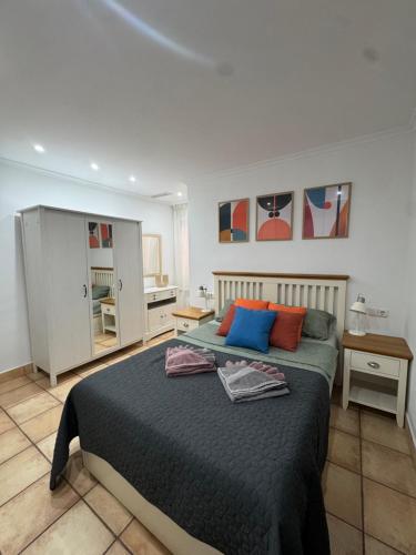 サンタ・ポラにあるApartamento CAMPAのベッドルーム1室(青とオレンジの枕が備わるベッド1台付)