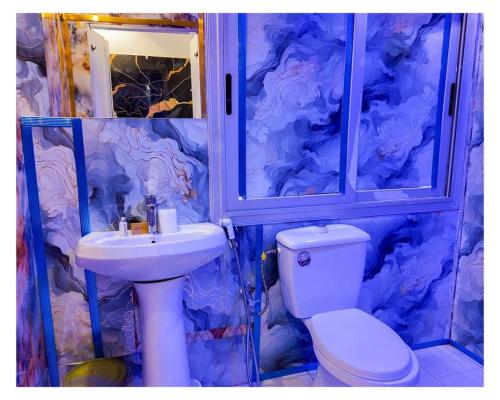 Un baño con un inodoro blanco y un lavabo. en Hotel Residence Ami Bamba, en Sali Nianiaral