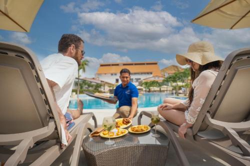 a group of people sitting around a table by a pool at Casa Andina Select Zorritos Tumbes in Zorritos
