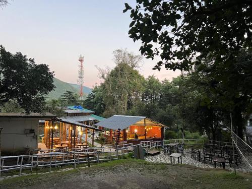 un edificio con tavoli e sedie di fronte di Heritage House by Himtrek Stays, Mcleodganj a Dharamsala