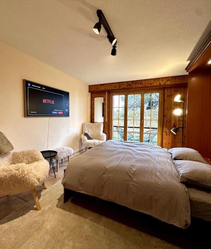 a bedroom with a bed and a tv on the wall at Pied de piste et à 5min des Bains d'Hérémence in Vex