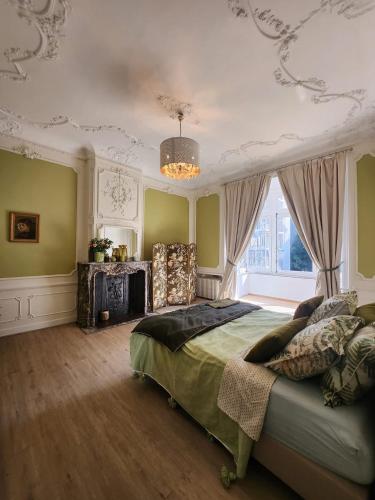 a bedroom with a bed and a chandelier at La villa Chatorya in Spa