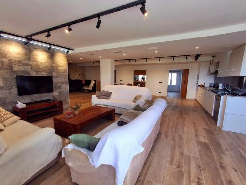 a living room with two couches and a kitchen at Can Pairot in Pujals dels Cavallers