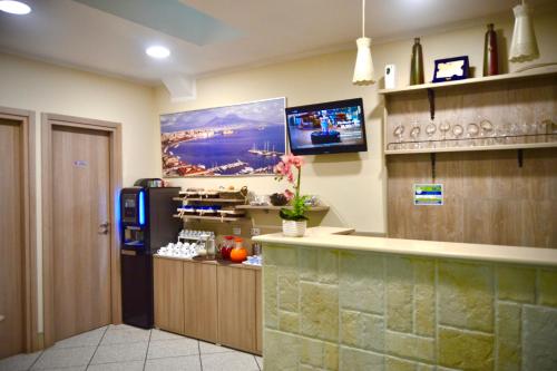 a kitchen with a refrigerator and a tv on the wall at Hotel Colombo in Naples