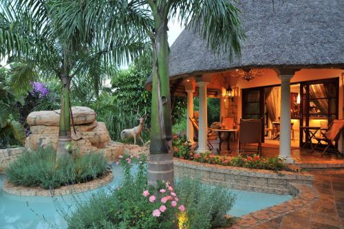 a home with a resort with a pond and palm trees at Summerfield Botanical Garden & Exclusive Resort in Matsapha