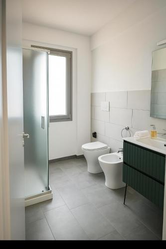 a bathroom with a shower and a toilet and a sink at Acquaria Case Vacanze in Marsala
