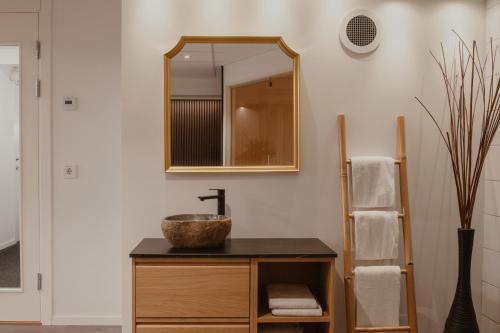 a bathroom with a sink and a mirror at Home Hotel Cardinal in Växjö