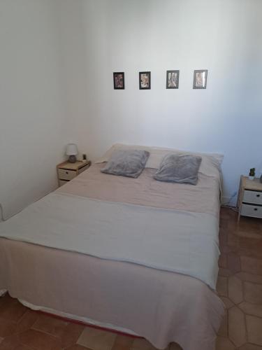 una camera da letto con un letto bianco e quadri appesi al muro di Los Dorados a Peñíscola