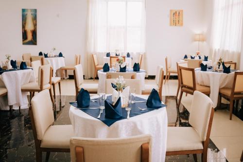 a dining room with white tables and chairs at Tolip Olympia Hotel in Addis Ababa