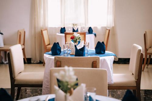 a dining room with a table and chairs with flowers on it at Tolip Olympia Hotel in Addis Ababa