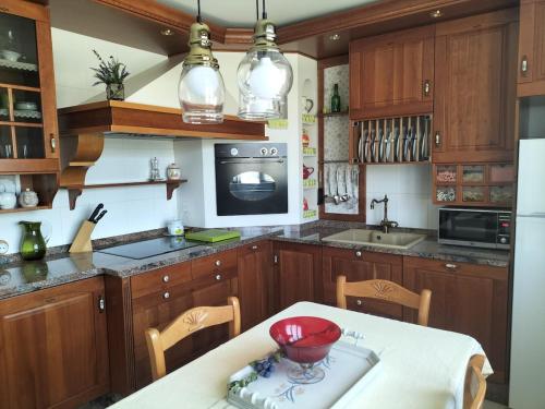 eine Küche mit Holzschränken und einem Tisch mit einer roten Schüssel darauf in der Unterkunft Casa Boutique I Nestares I 6 pax I calm and comfort in Reinosa