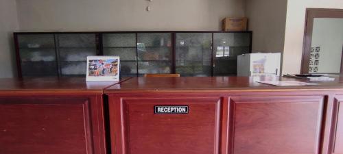 EnrekangにあるOYO 93051 Wisma Syariah Buloe Near Lapangan Abubakar Lambogo Batili Enrekangの受付の看板を持つ赤い棚