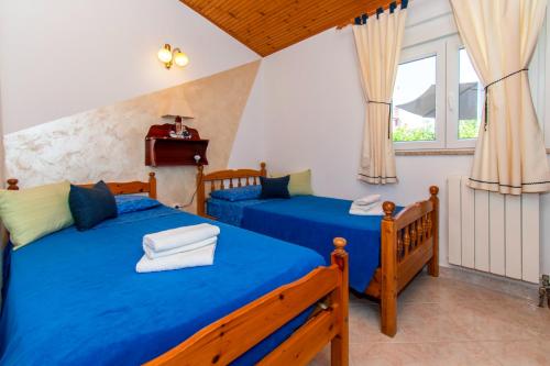 two beds in a room with two windows at House Nicol Fazana in Fažana