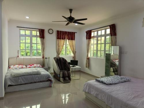 a bedroom with two beds and a ceiling fan at 主人房玻璃市港口 in Kuala Perlis