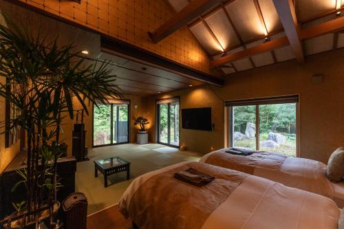 a large bedroom with two beds and a tv at 箱根懐來 in Hakone