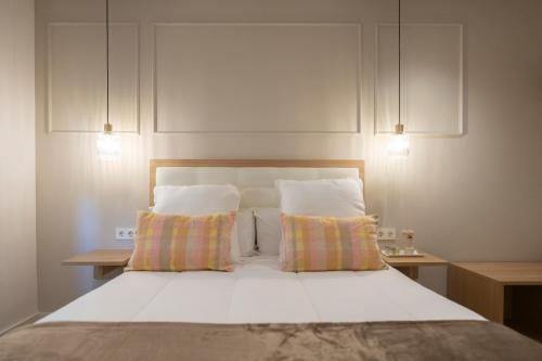 a bedroom with a white bed with two pillows at Pension Del Mar in Donostia-San Sebastián