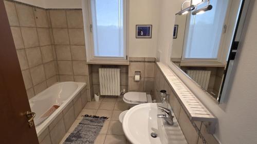 Un baño con lavabo, bañera e inodoro. en Condo-Micio Luna, en Azzano