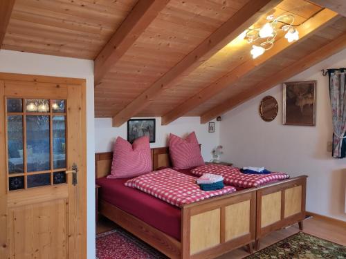1 dormitorio con 1 cama con almohadas rosas en Ferienwohnungen Eisele, en Bad Feilnbach