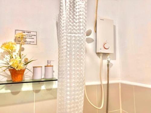 Una cortina de ducha en un baño con flores en un estante en Attractive studio with Luxury bed Good for 1-4pax High speed WiFi with Netflix Free Pool & Parking, en Suba