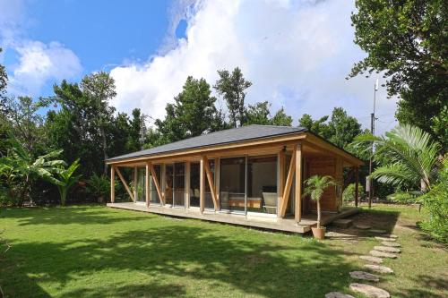 a small house in a yard with a green lawn at 久米島 SHINMINKA Villa in Kumejima