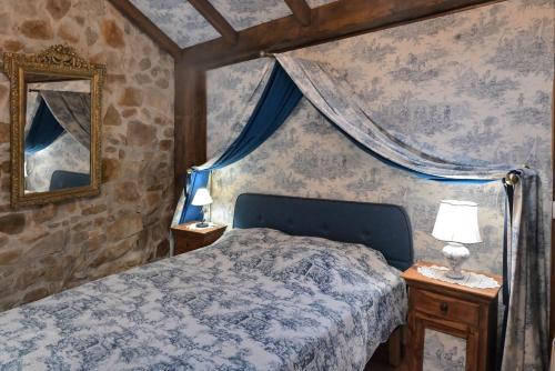 une chambre avec un lit et un miroir dans l'établissement Le BASTIDON de CHANTE PIERRE, à Cuers