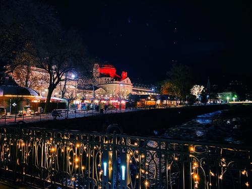 a city lit up at night with christmas lights at Residence Pranterhof in Marlengo