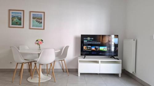 a living room with a tv and a table with chairs at Beautiful 43m2 with two double beds everything nearby in Nice