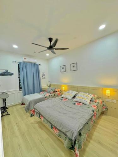 a bedroom with two beds and a ceiling fan at Homestay DEEDORA in Seri Manjung